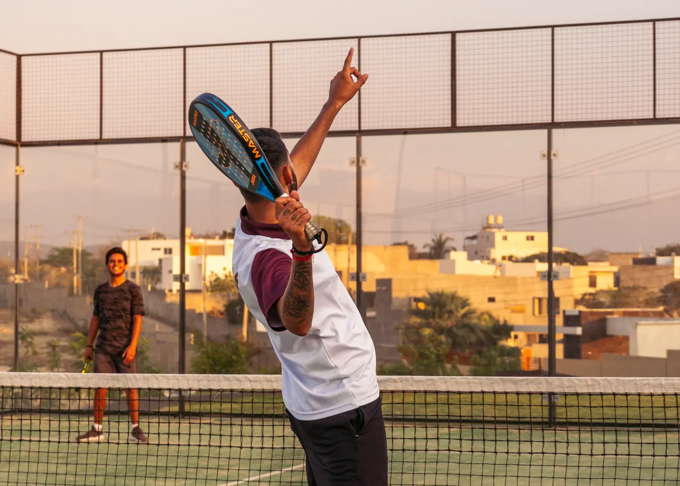 Cancha de pádel con jugadores al atardecer